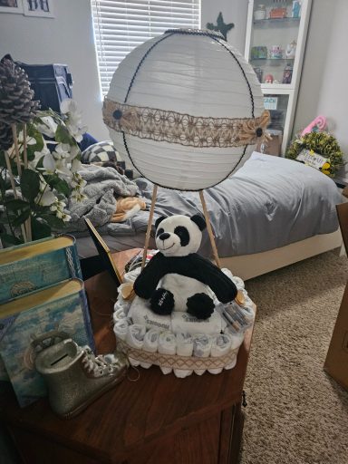 A panda figure in a hot air balloon made from fabric and decorations.