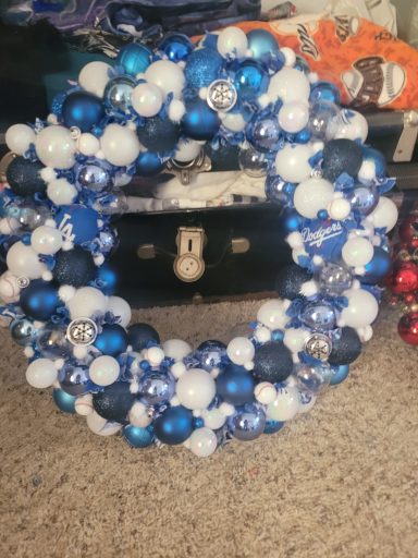 A circular wreath made of blue and white decorative baubles.