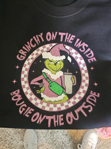 A cartoon Grinch in festive attire holding a drink, with "Grinchy on the inside" text.
