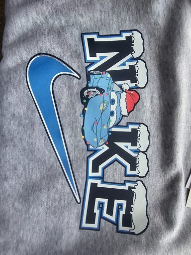 Nike logo with stylized lettering and a cartoon car wearing a Santa hat.