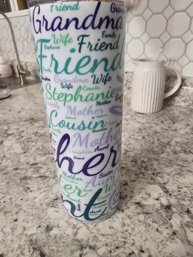 A tall cup covered in colorful words like "Grandma," "Friend," and "Cousin."